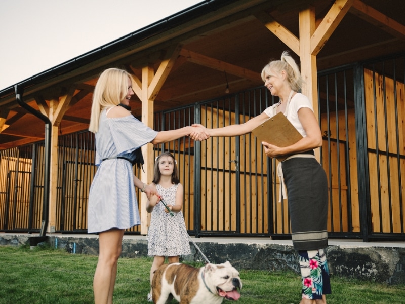 Family meets facility staff to prepare for boarding a dog for a week safely.